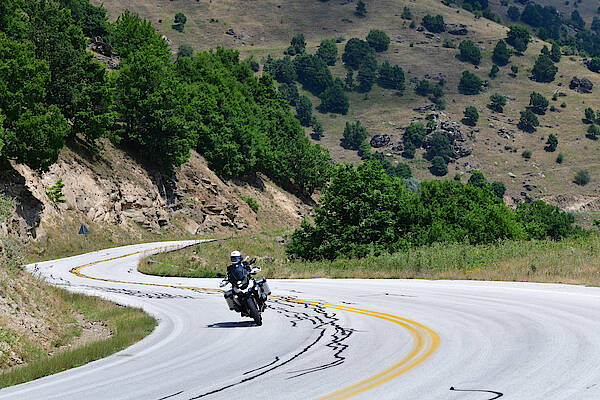 Ein Motorrad fährt mit Schräglage durch griechische Kurven